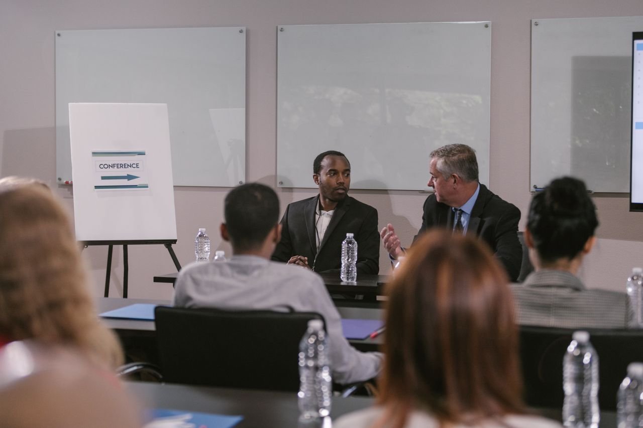 Business professionals engage in a lively discussion during a corporate conference. Indoor setting.